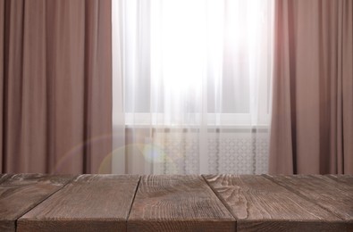 Image of Empty wooden table near window with curtains. Space for design