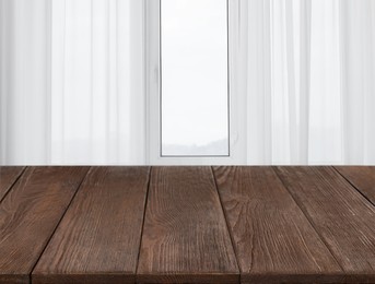 Image of Empty wooden table near window with curtains. Space for design