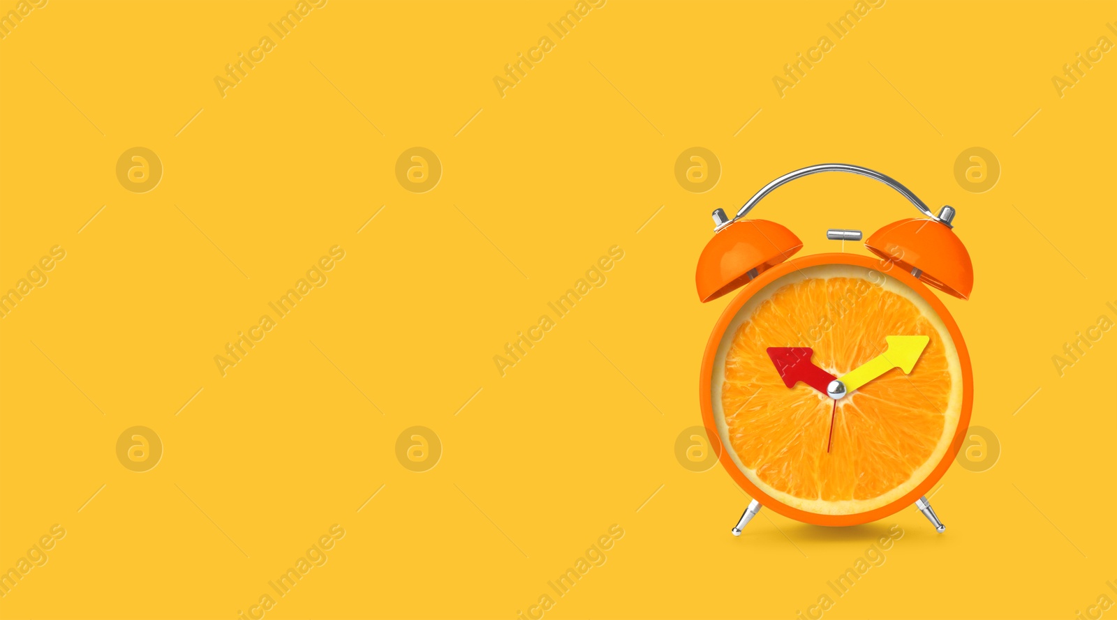 Image of Juicy orange on alarm clock dial against golden background. Creative poster with space for text, banner design