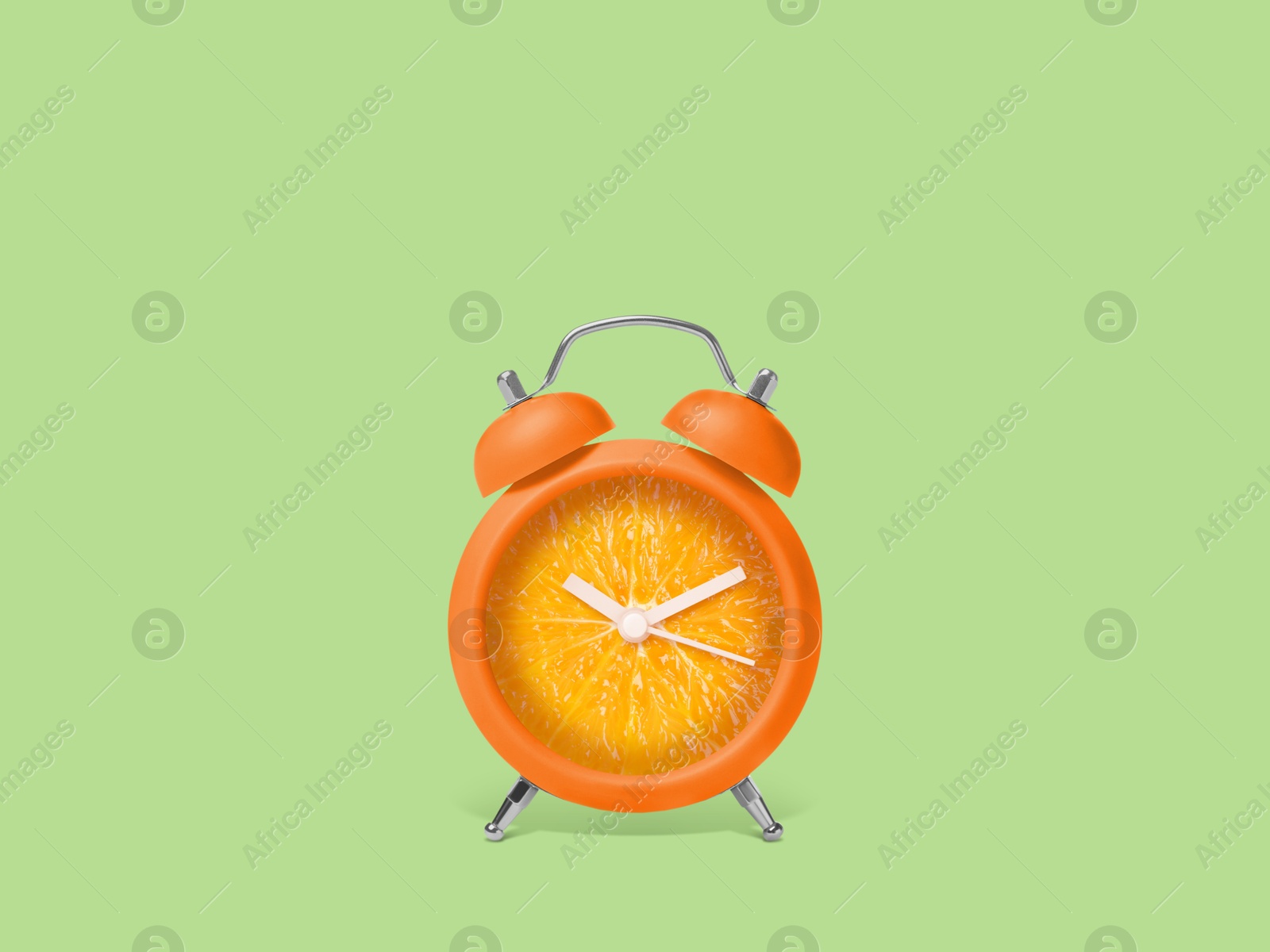 Image of Juicy orange on alarm clock dial against light green background. Creative poster