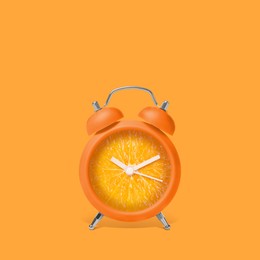 Image of Juicy orange on alarm clock dial against orange background. Creative poster