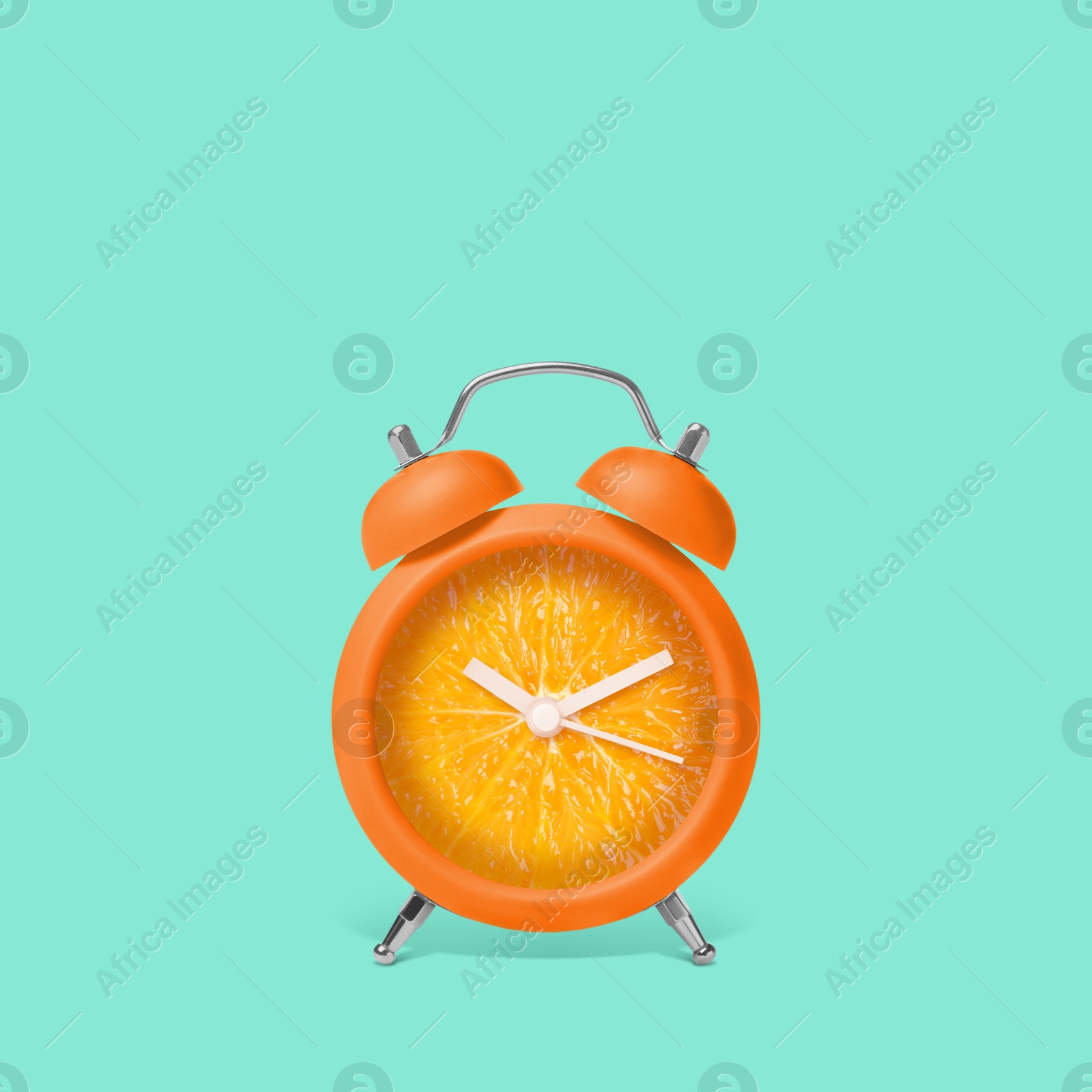 Image of Juicy orange on alarm clock dial against turquoise background. Creative poster