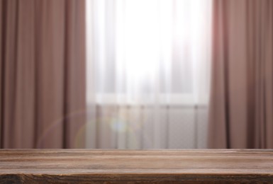 Image of Empty wooden table near window with curtains. Space for design