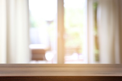 Image of Empty wooden table near window with curtains. Space for design