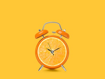 Image of Juicy orange on alarm clock dial against golden background. Creative poster