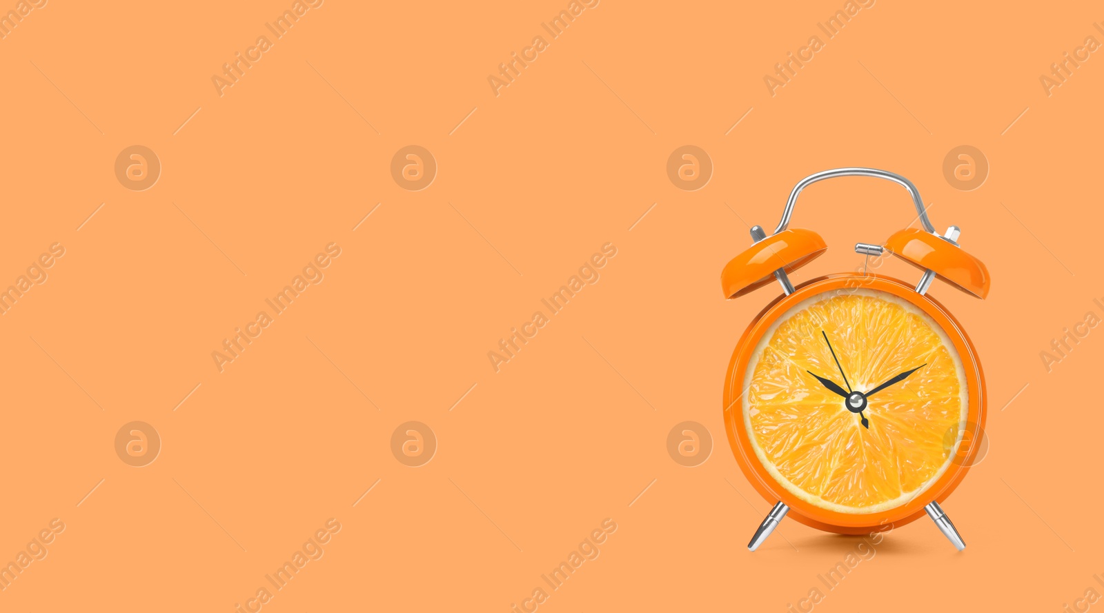 Image of Juicy orange on alarm clock dial against light coral background. Creative poster with space for text, banner design