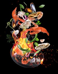 Image of Sea food, vegetables, herbs, spices and frying pan in air on black background. Cooking meal