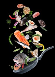 Image of Sea food, vegetables, herbs, spices and frying pan in air on black background. Cooking meal