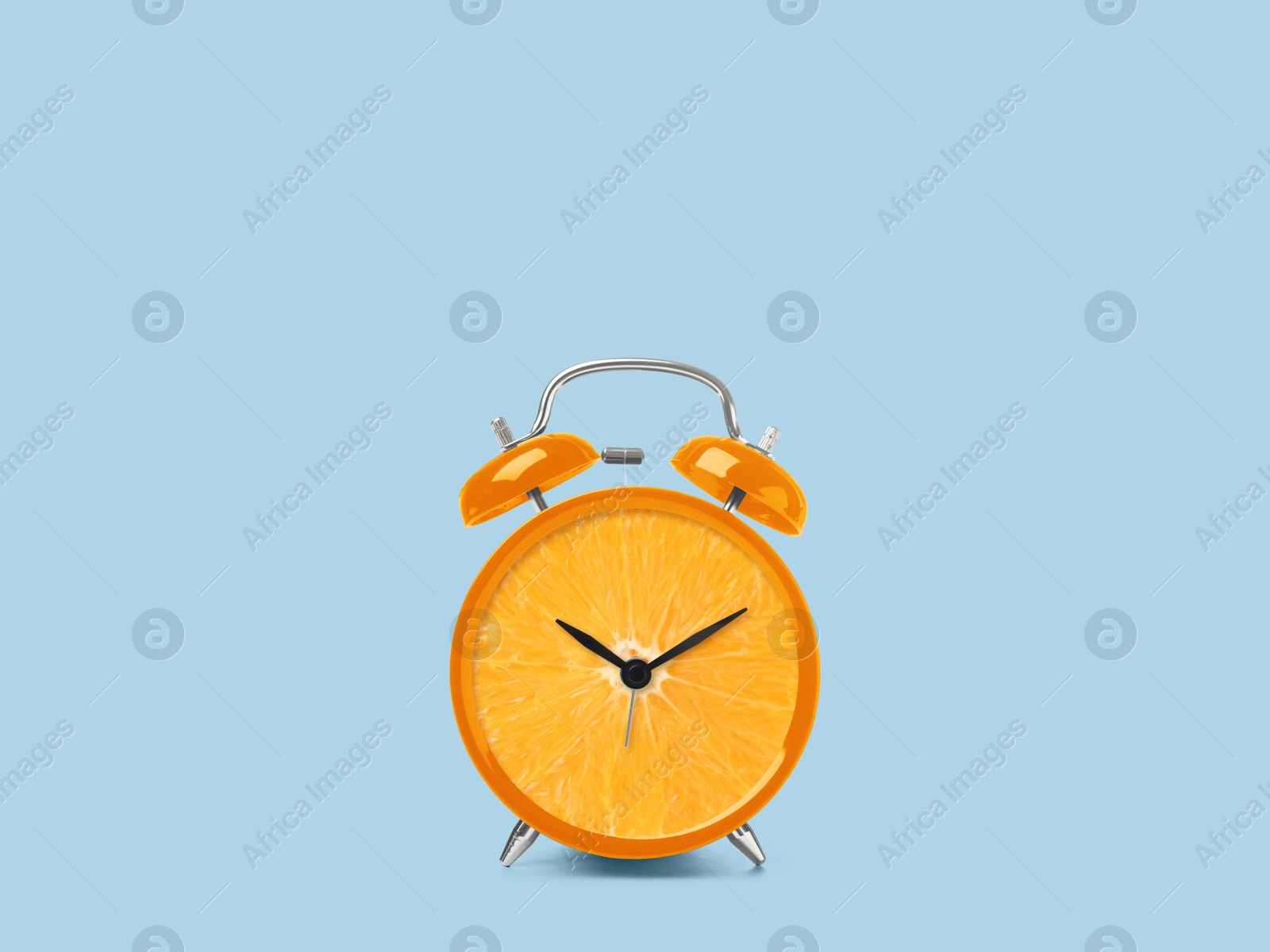 Image of Juicy orange on alarm clock dial against light blue background. Creative poster