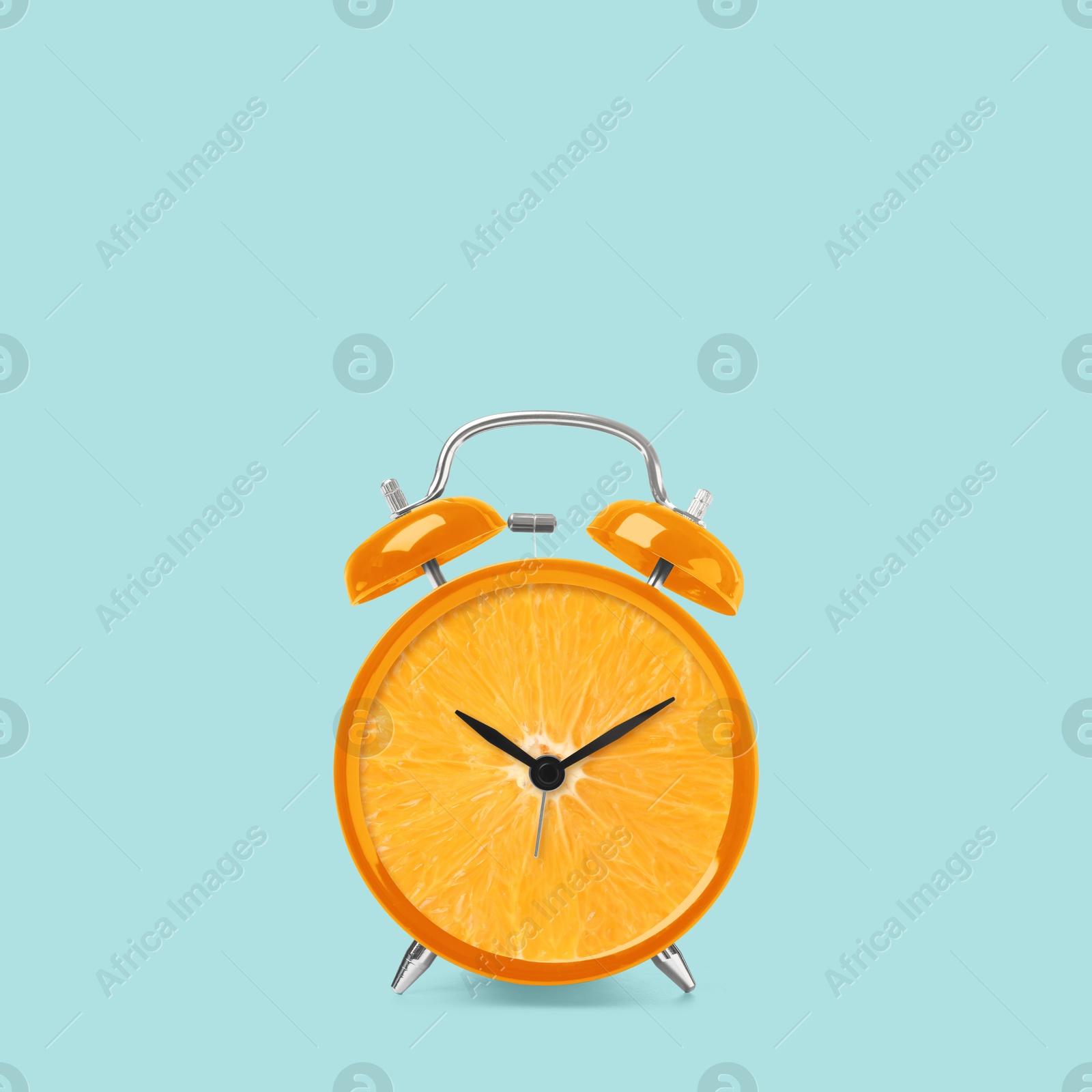 Image of Juicy orange on alarm clock dial against light blue background. Creative poster