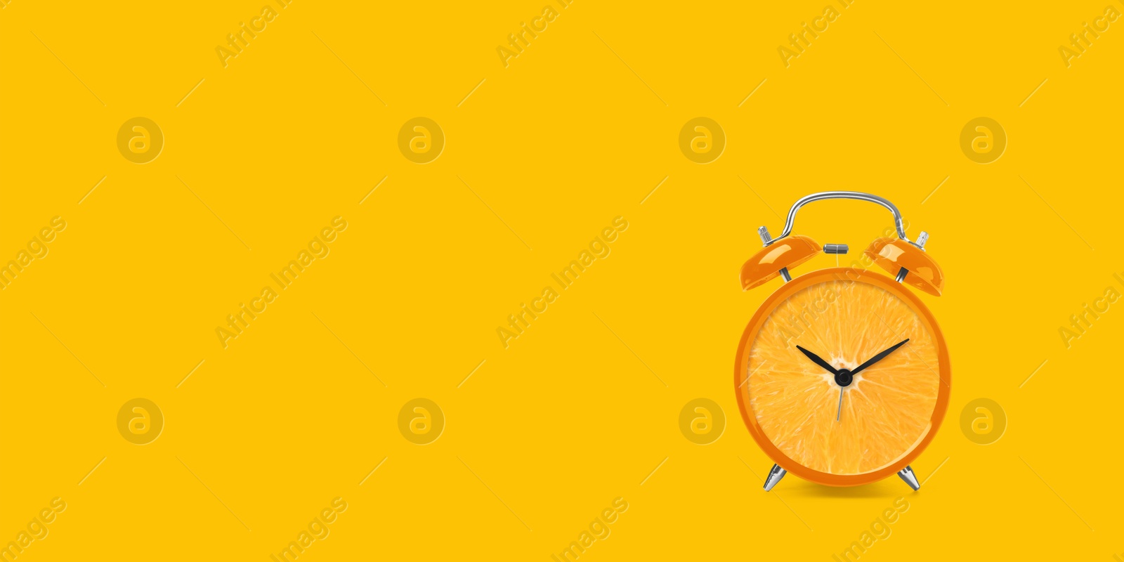 Image of Juicy orange on alarm clock dial against golden background. Creative poster with space for text, banner design