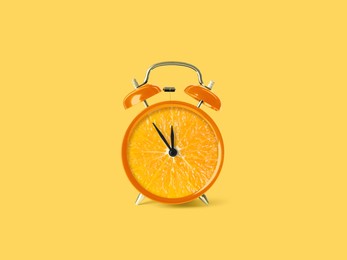 Juicy orange on alarm clock dial against light orange background. Creative poster