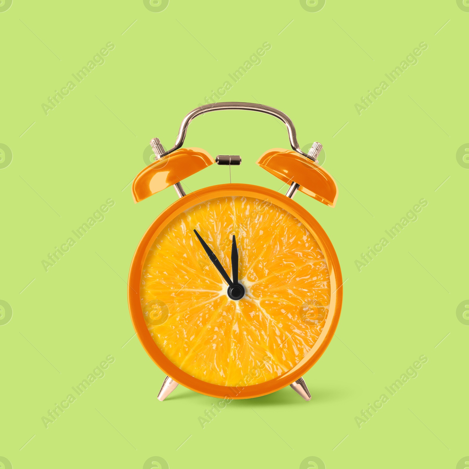 Image of Juicy orange on alarm clock dial against light green background. Creative poster