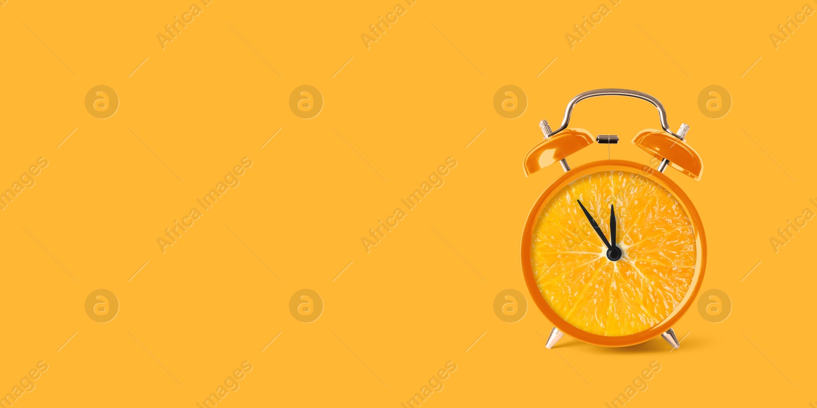 Image of Juicy orange on alarm clock dial against orange background. Creative poster with space for text, banner design