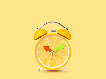 Juicy lemon on alarm clock dial against light yellow background. Creative poster