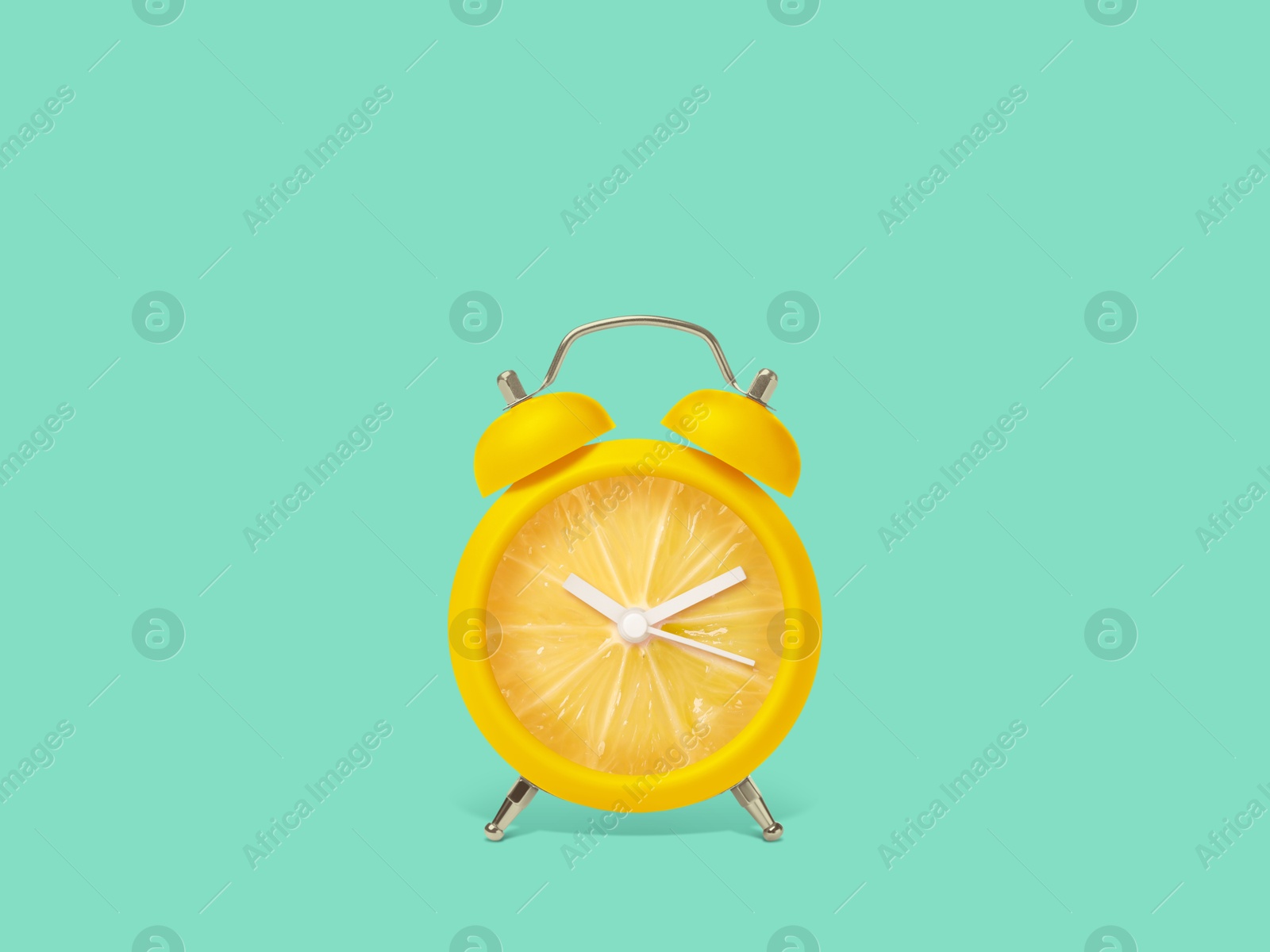 Image of Juicy lemon on alarm clock dial against turquoise background. Creative poster