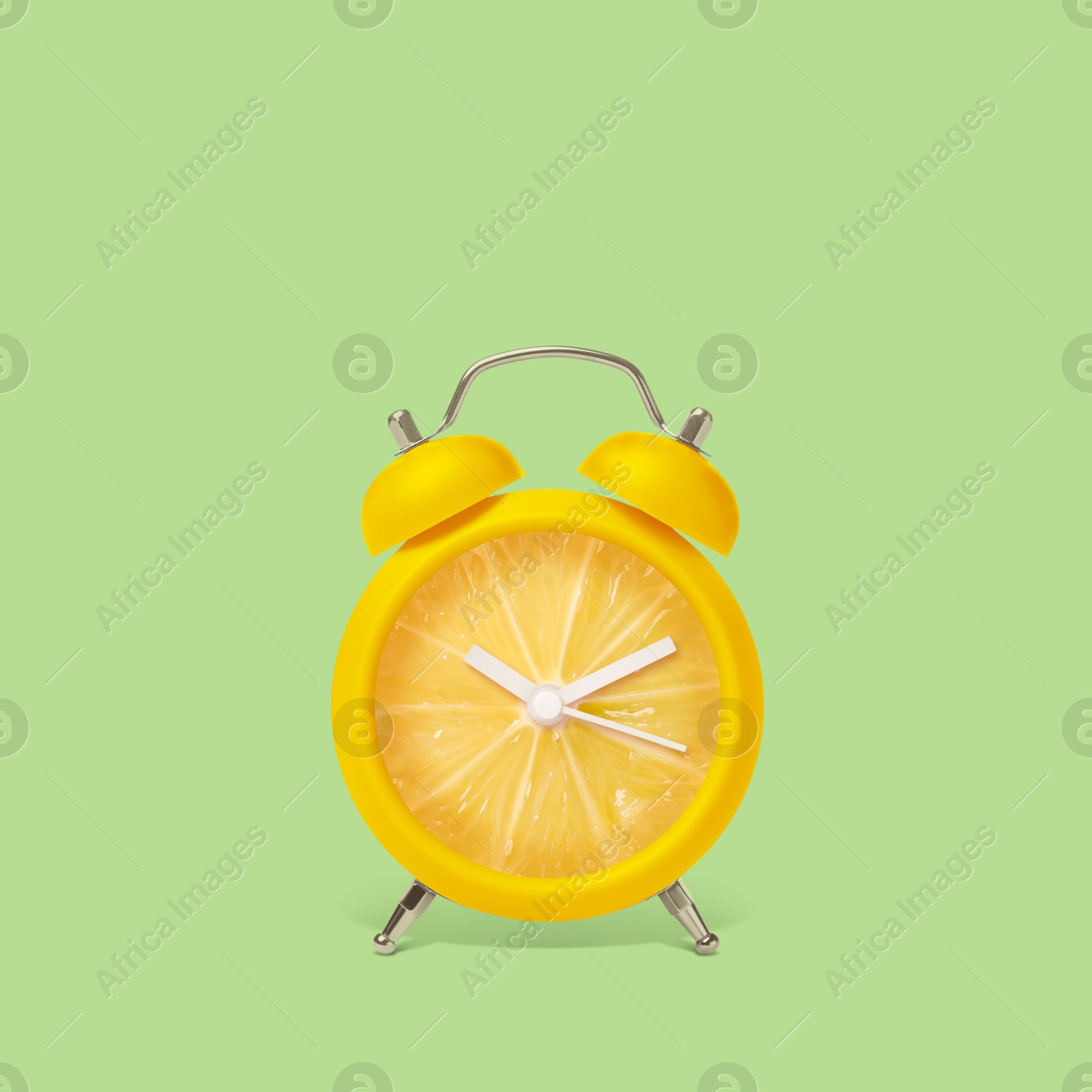 Image of Juicy lemon on alarm clock dial against light green background. Creative poster