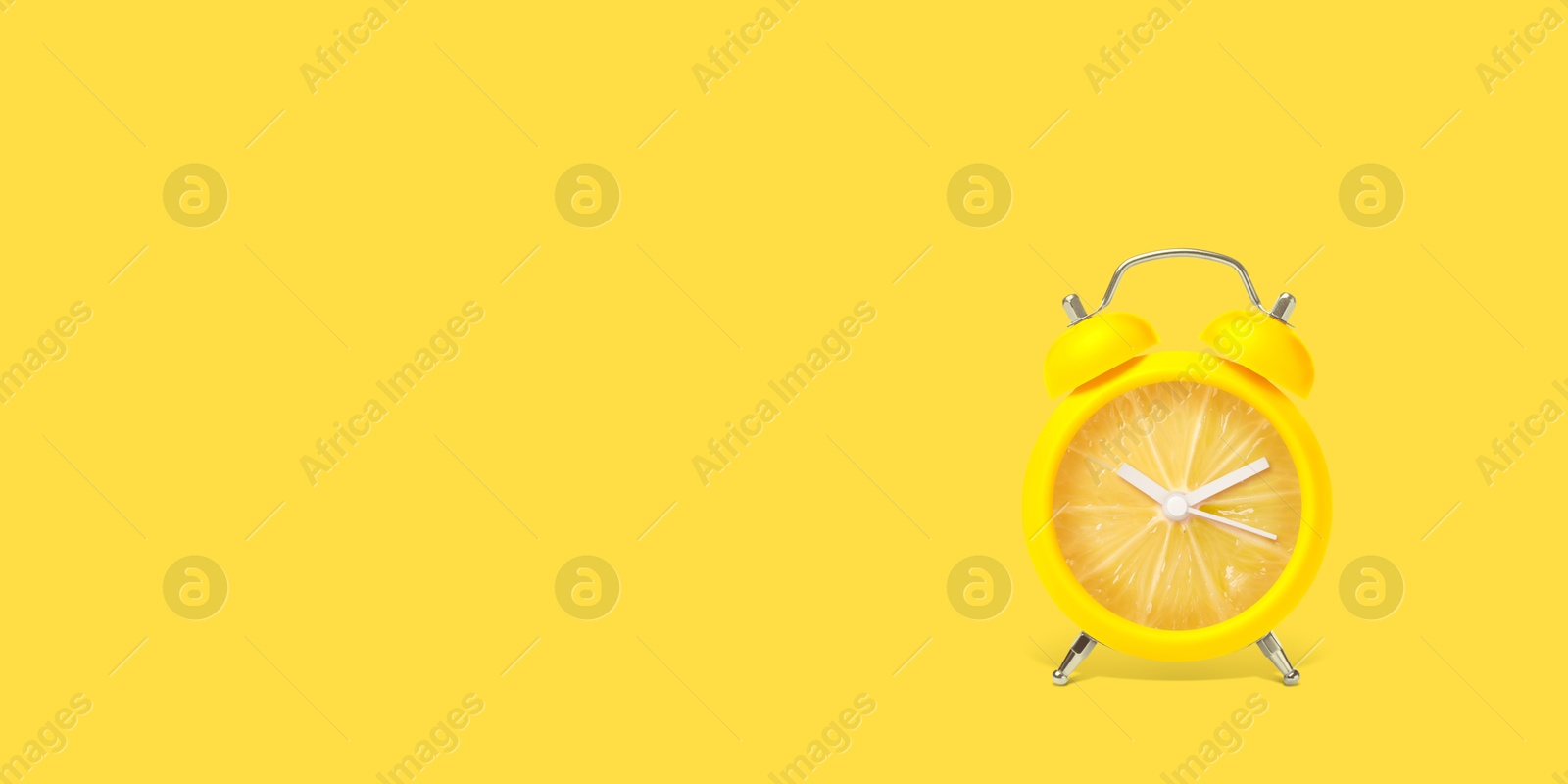 Image of Juicy lemon on alarm clock dial against yellow background. Creative poster with space for text, banner design