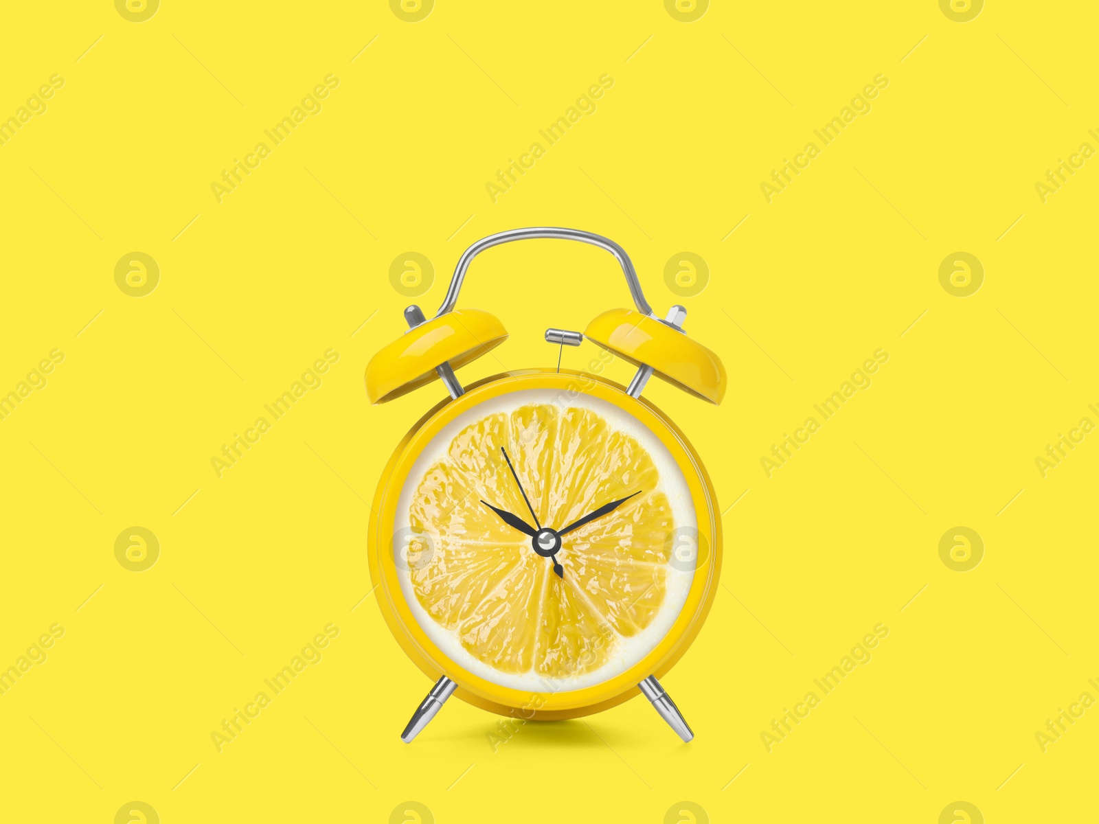 Image of Juicy lemon on alarm clock dial against yellow background. Creative poster