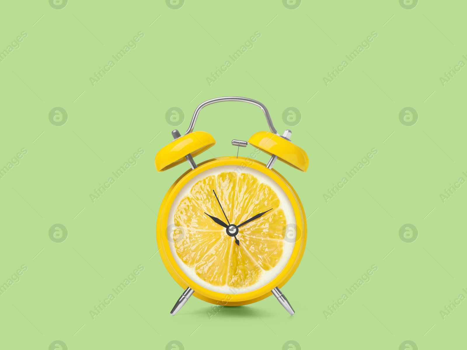 Image of Juicy lemon on alarm clock dial against light green background. Creative poster