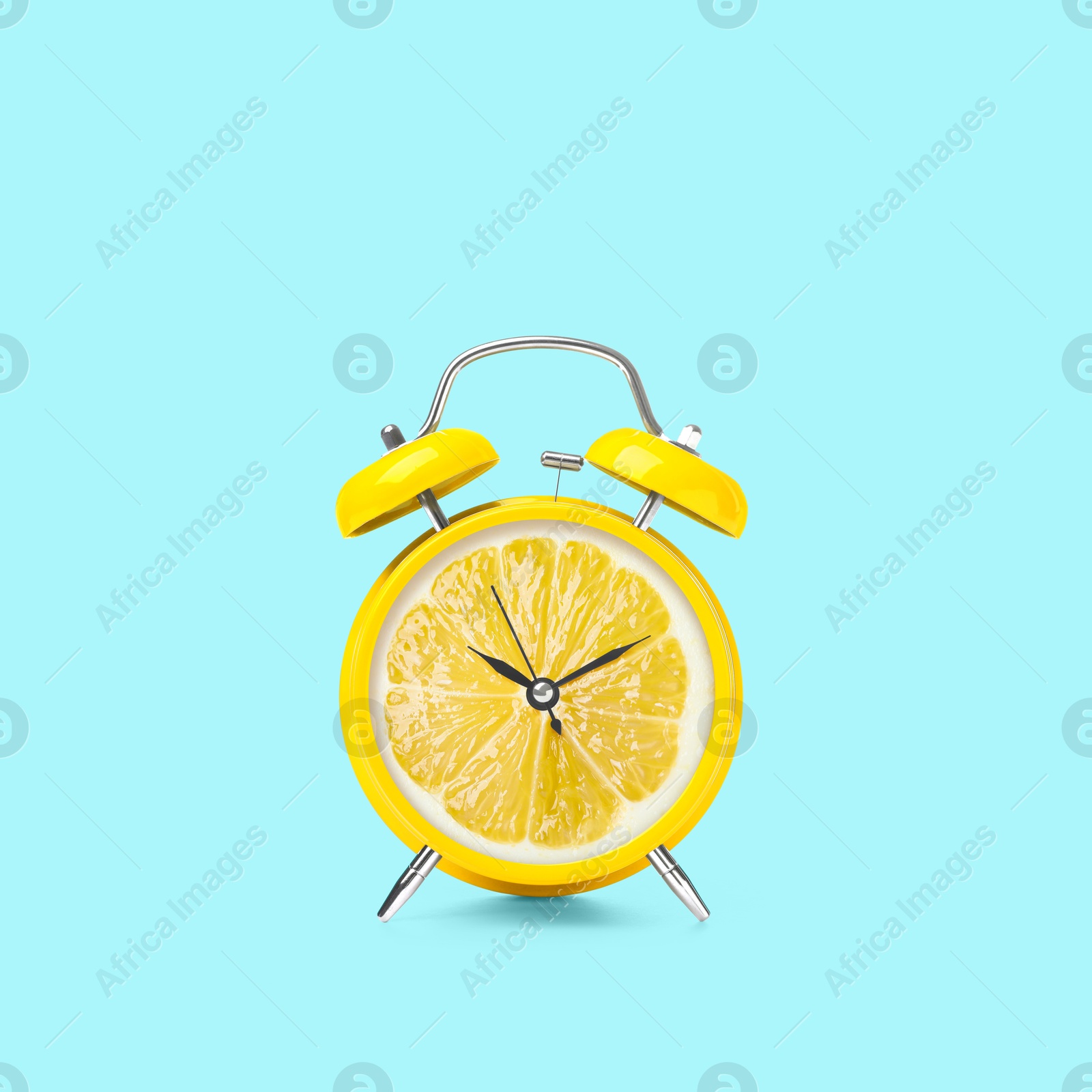 Image of Juicy lemon on alarm clock dial against light blue background. Creative poster