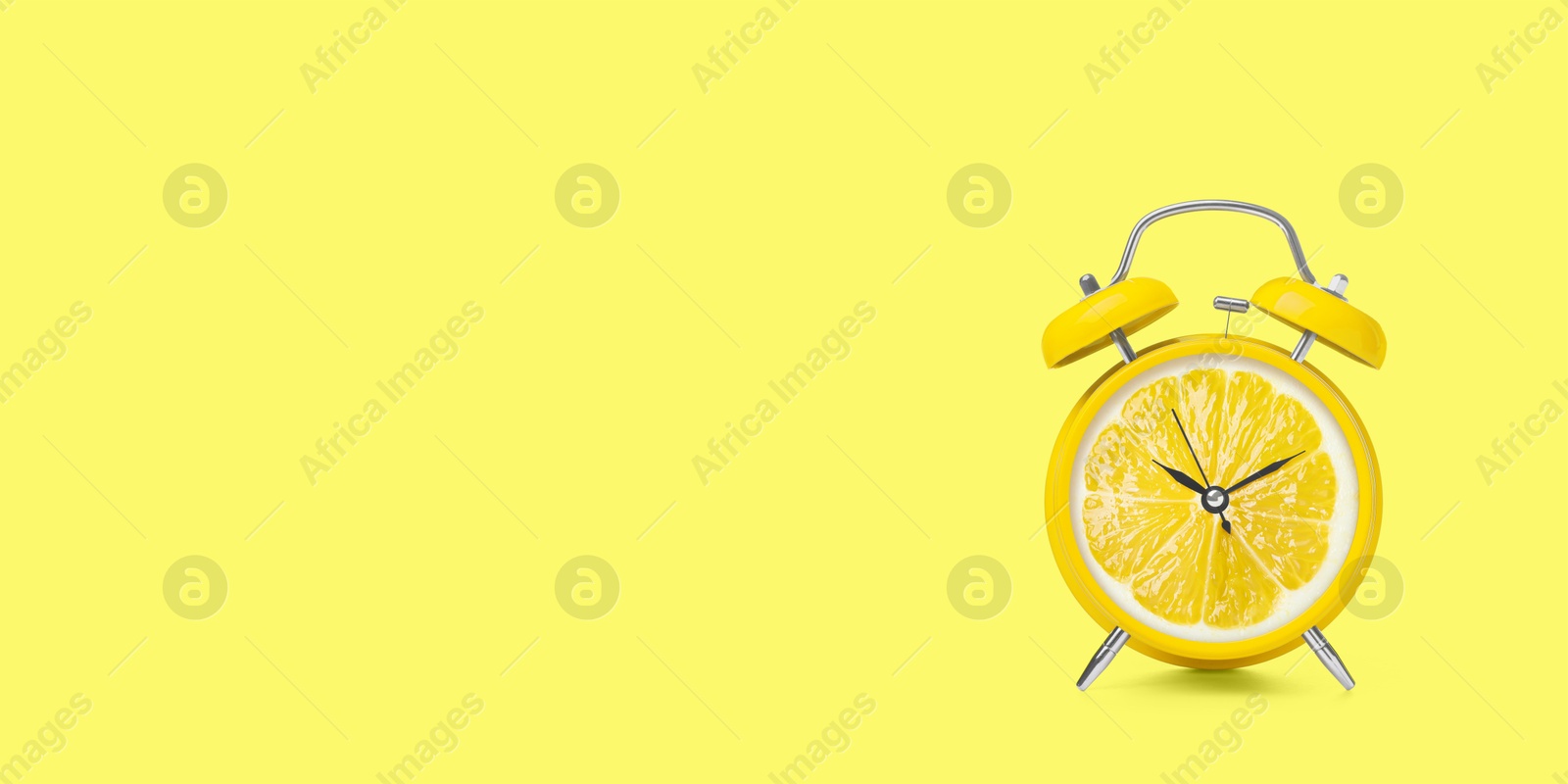 Image of Juicy lemon on alarm clock dial against light yellow background. Creative poster with space for text, banner design