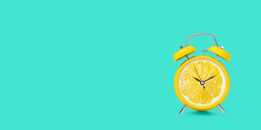 Juicy lemon on alarm clock dial against turquoise background. Creative poster with space for text, banner design