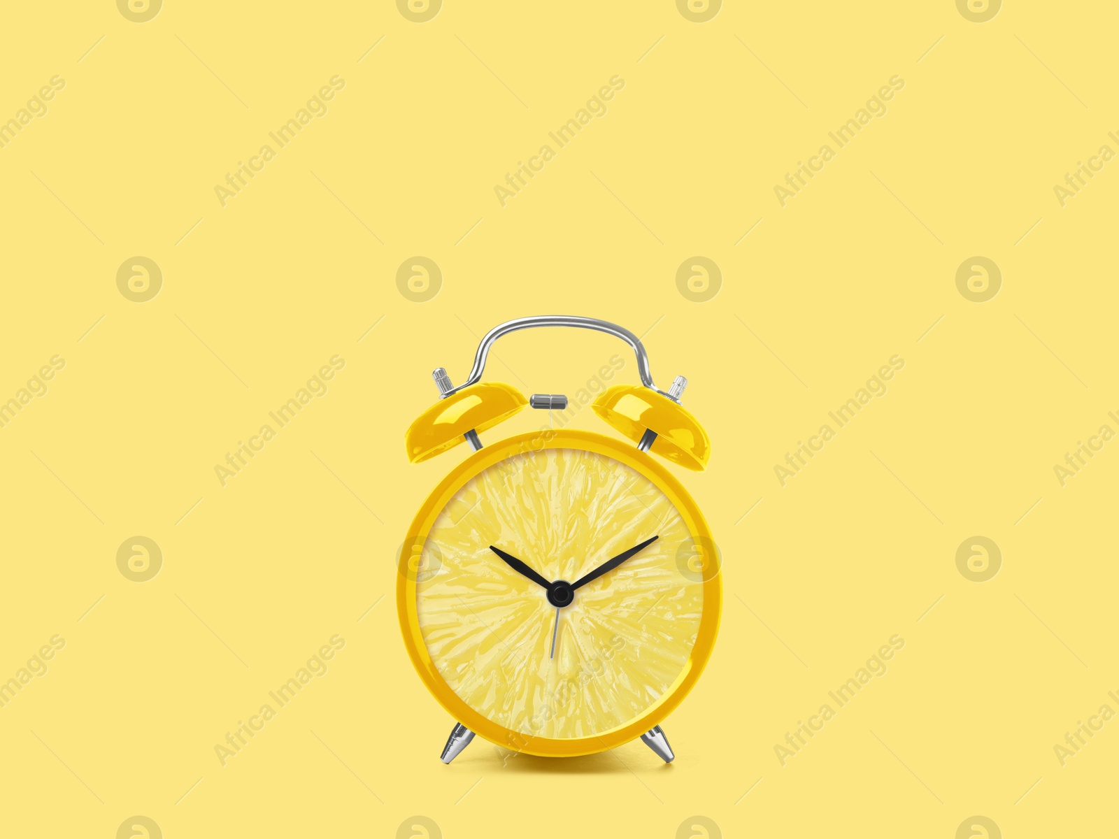 Image of Juicy lemon on alarm clock dial against light yellow background. Creative poster