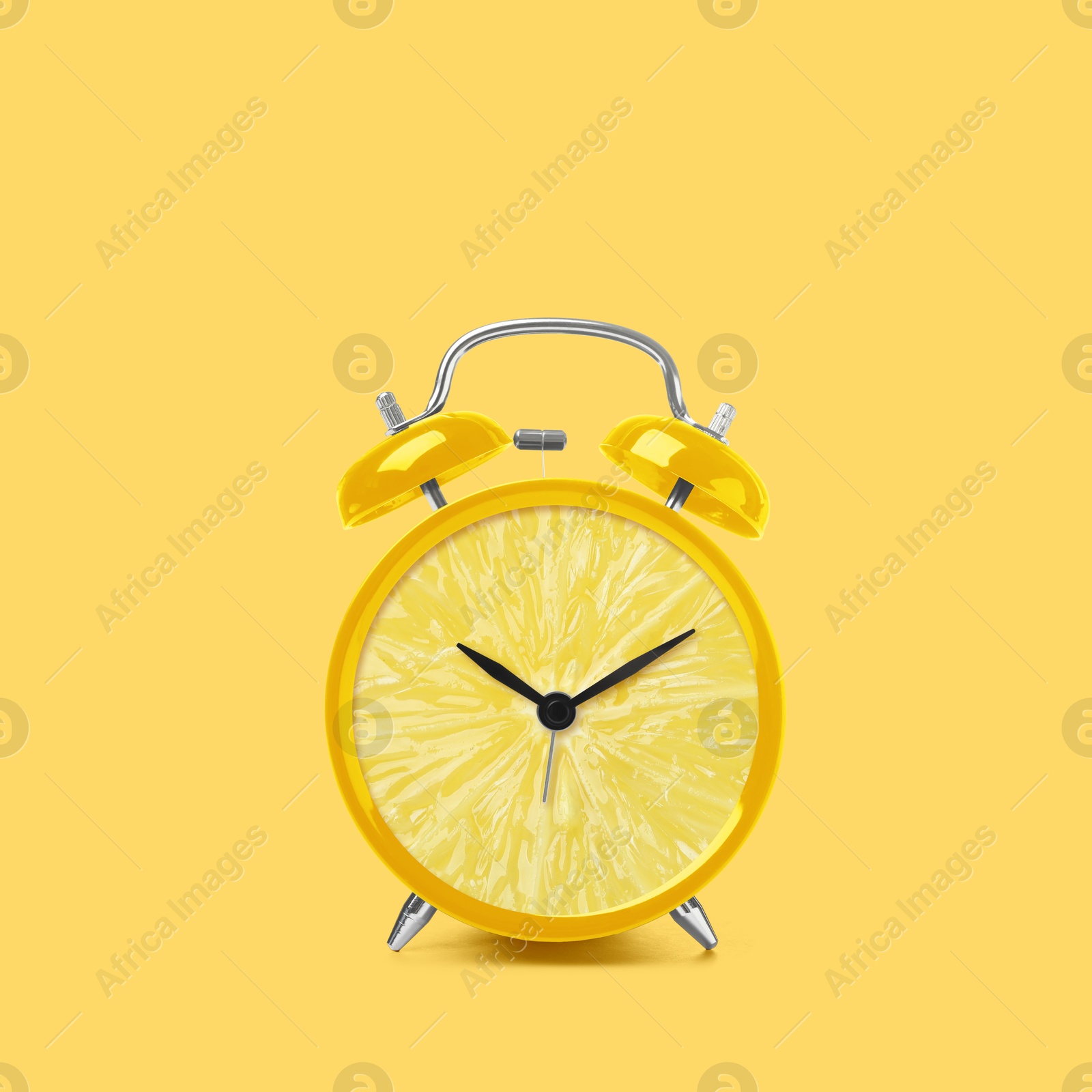 Image of Juicy lemon on alarm clock dial against light yellow background. Creative poster