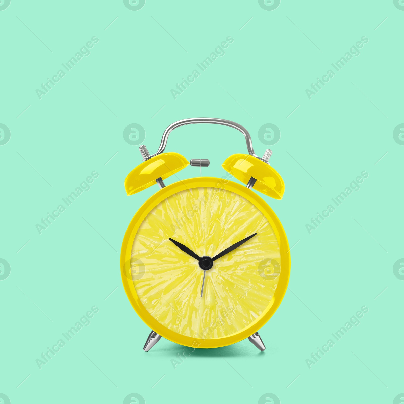 Image of Juicy lemon on alarm clock dial against light turquoise background. Creative poster