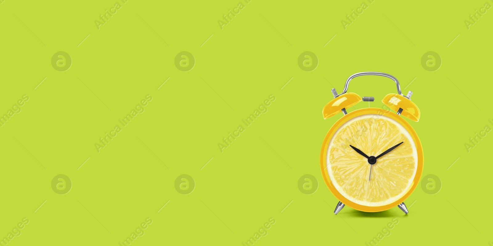 Image of Juicy lemon on alarm clock dial against light green background. Creative poster with space for text, banner design