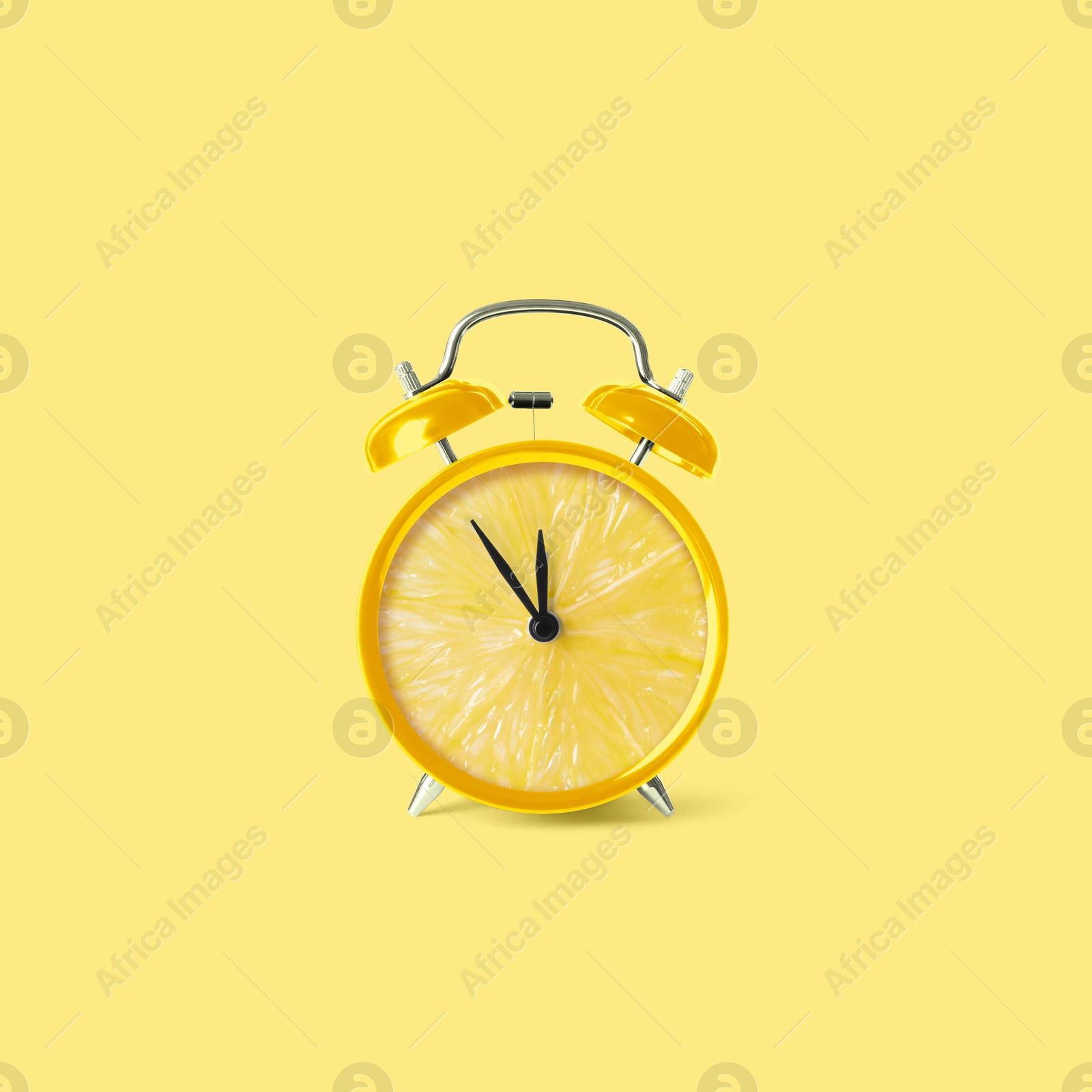 Image of Juicy lemon on alarm clock dial against light yellow background. Creative poster