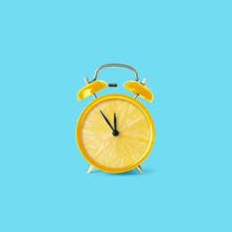 Image of Juicy lemon on alarm clock dial against light blue background. Creative poster