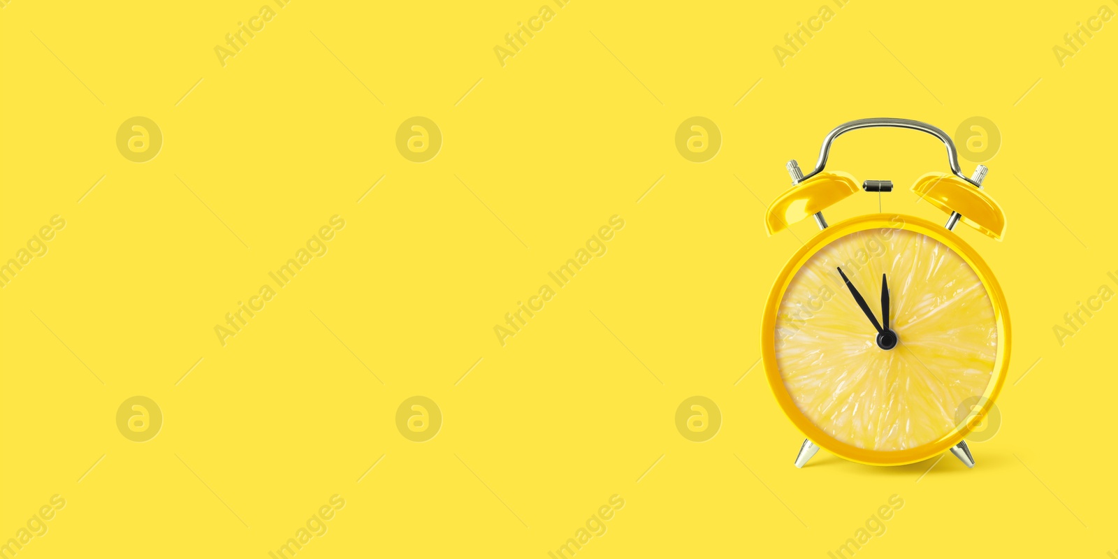 Image of Juicy lemon on alarm clock dial against yellow background. Creative poster with space for text, banner design