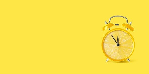 Juicy lemon on alarm clock dial against yellow background. Creative poster with space for text, banner design