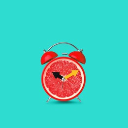 Image of Juicy grapefruit on alarm clock dial against turquoise background. Creative poster