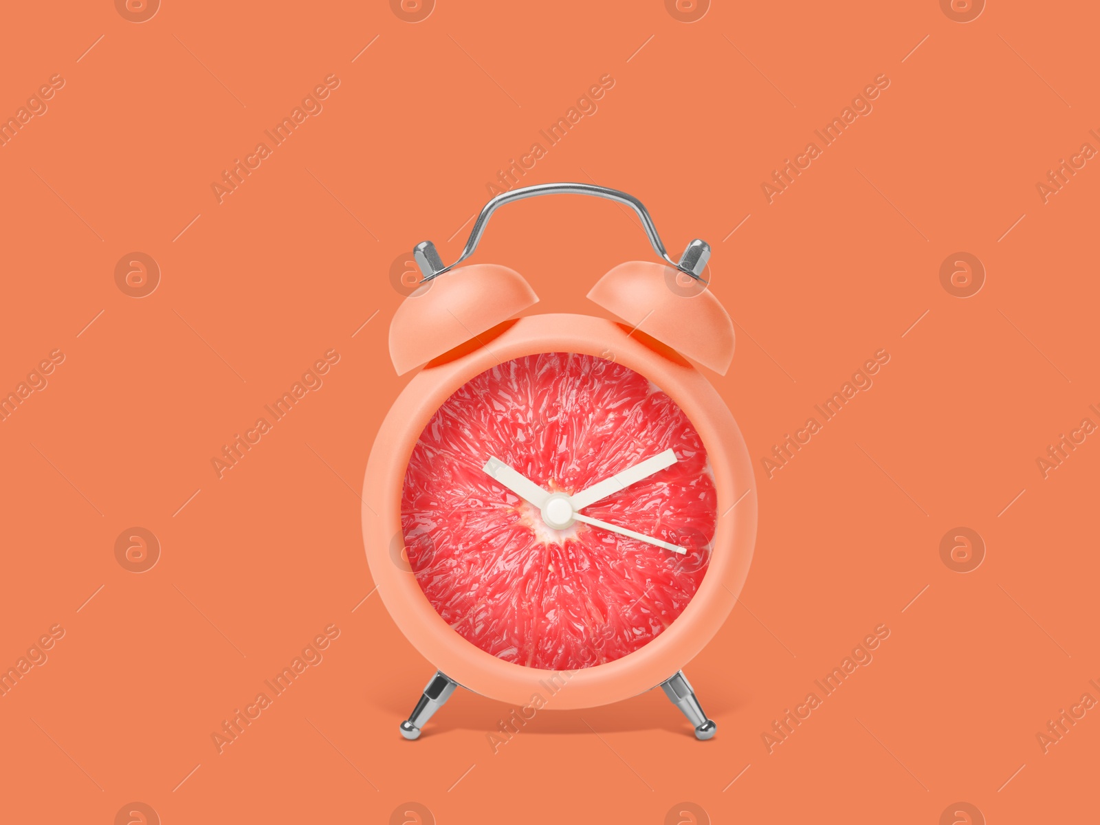 Image of Juicy grapefruit on alarm clock dial against orange background. Creative poster