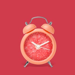 Image of Juicy grapefruit on alarm clock dial against crimson background. Creative poster