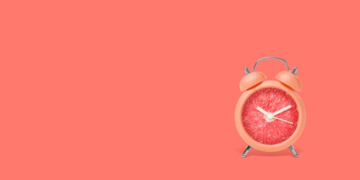 Image of Juicy grapefruit on alarm clock dial against dark coral background. Creative poster with space for text, banner design