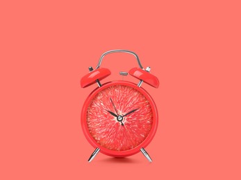 Image of Juicy grapefruit on alarm clock dial against dark coral background. Creative poster