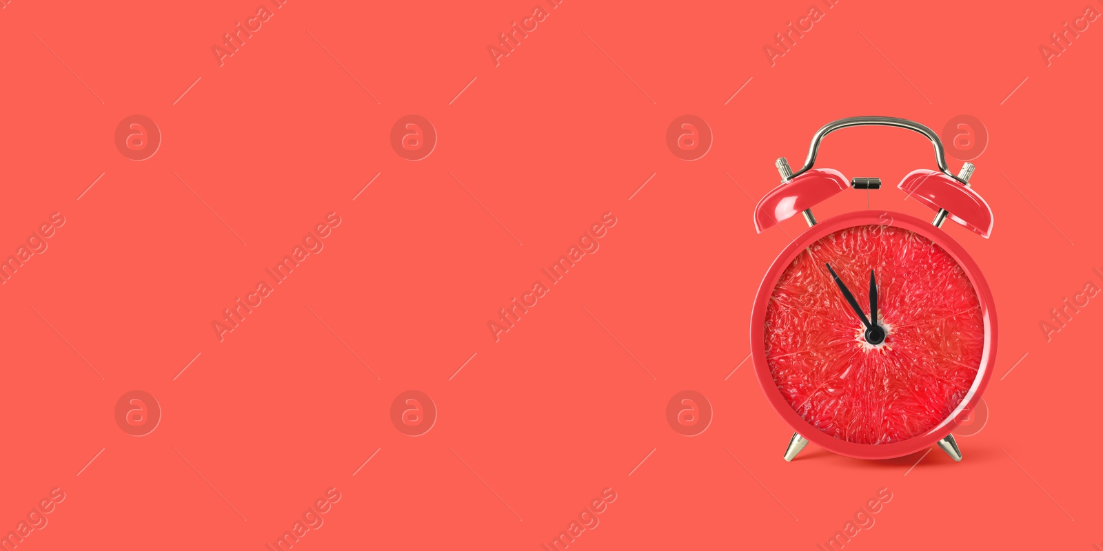 Image of Juicy grapefruit on alarm clock dial against red background. Creative poster with space for text, banner design