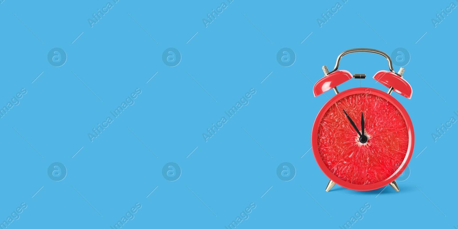 Image of Juicy grapefruit on alarm clock dial against light blue background. Creative poster with space for text, banner design