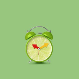 Juicy lime on alarm clock dial against light green background. Creative poster