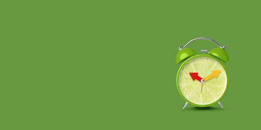 Image of Juicy lime on alarm clock dial against green background. Creative poster with space for text, banner design