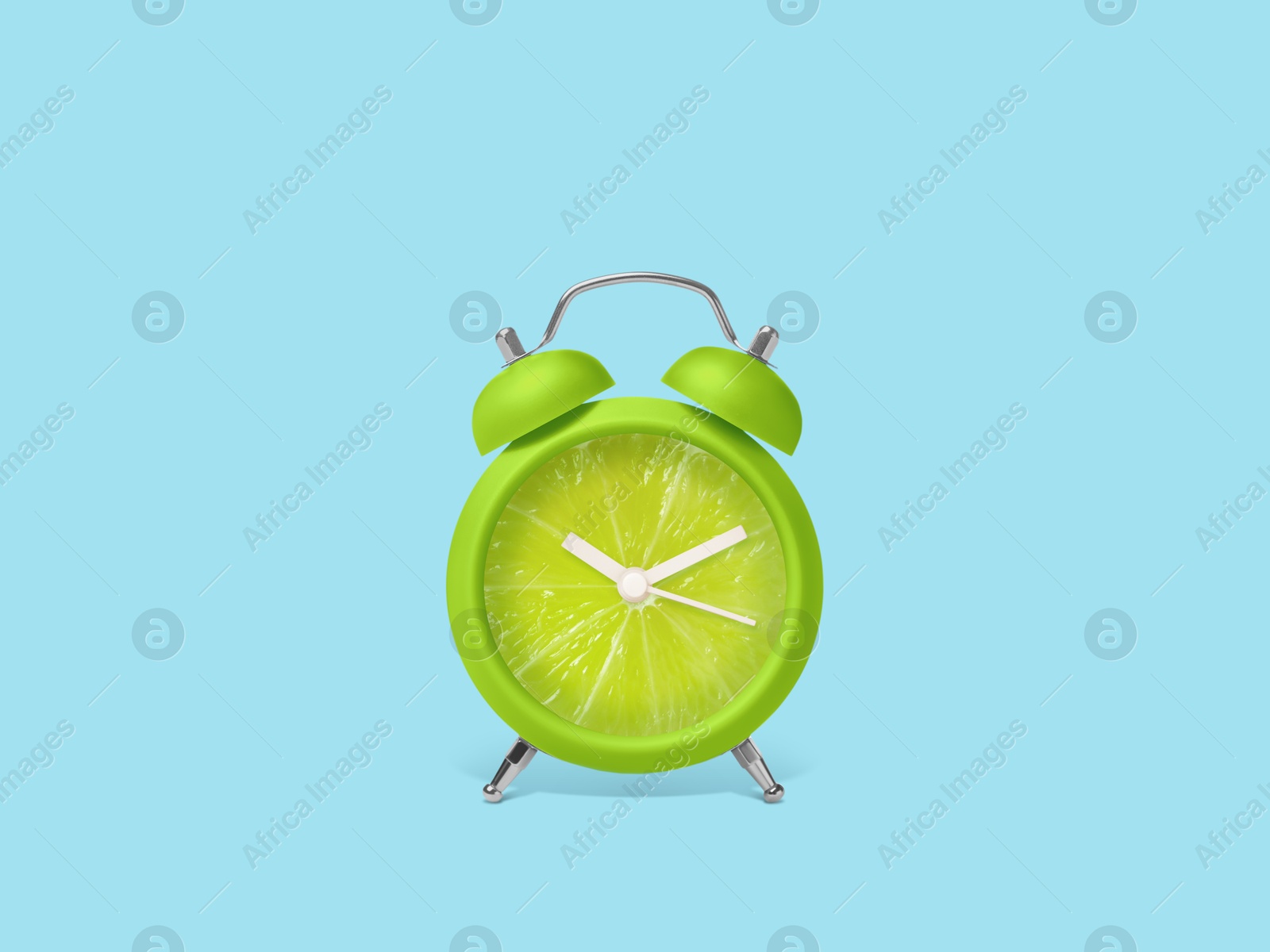 Image of Juicy lime on alarm clock dial against light blue background. Creative poster