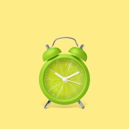 Image of Juicy lime on alarm clock dial against light blue yellow. Creative poster