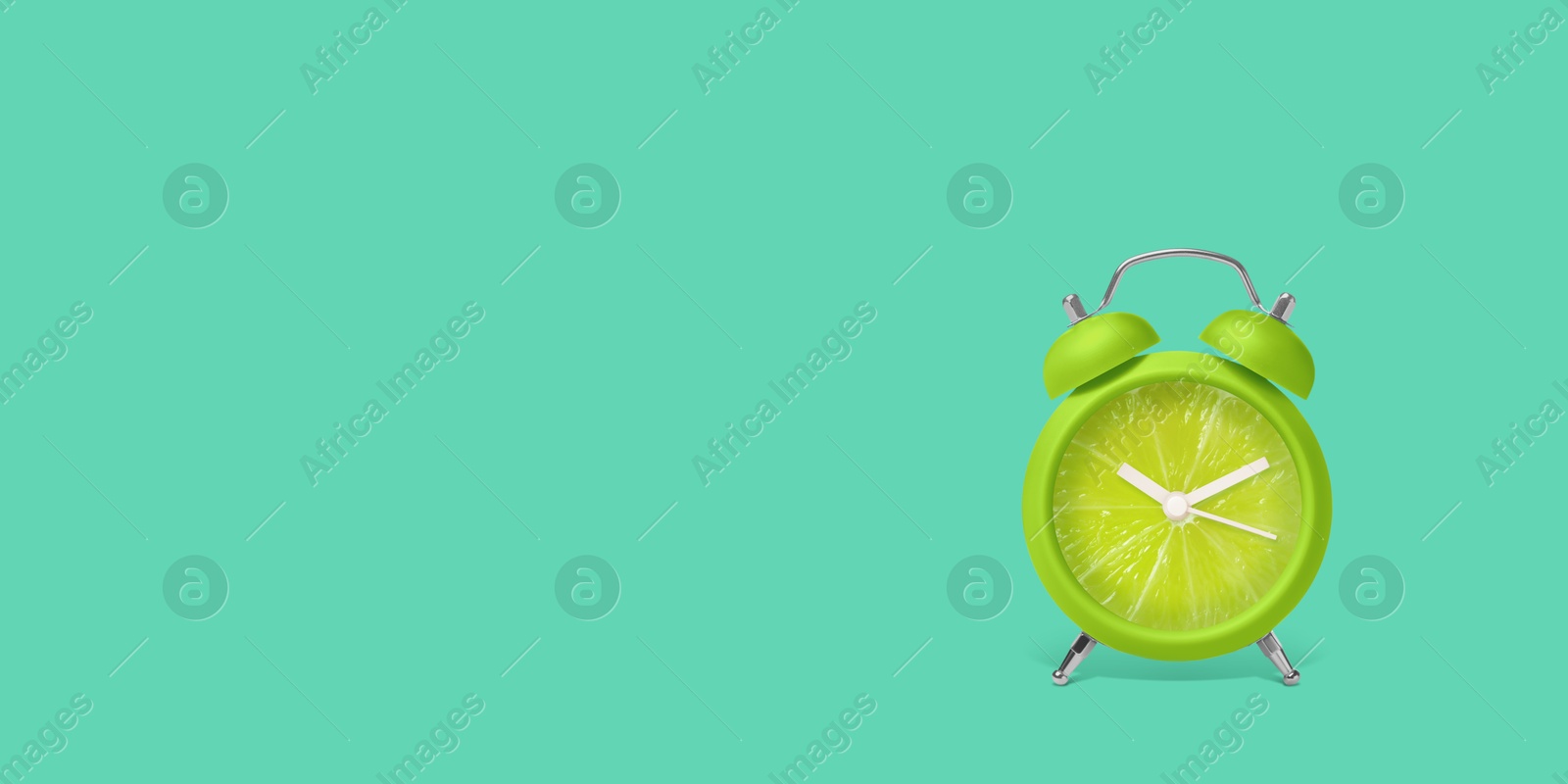 Image of Juicy lime on alarm clock dial against turquoise background. Creative poster with space for text, banner design