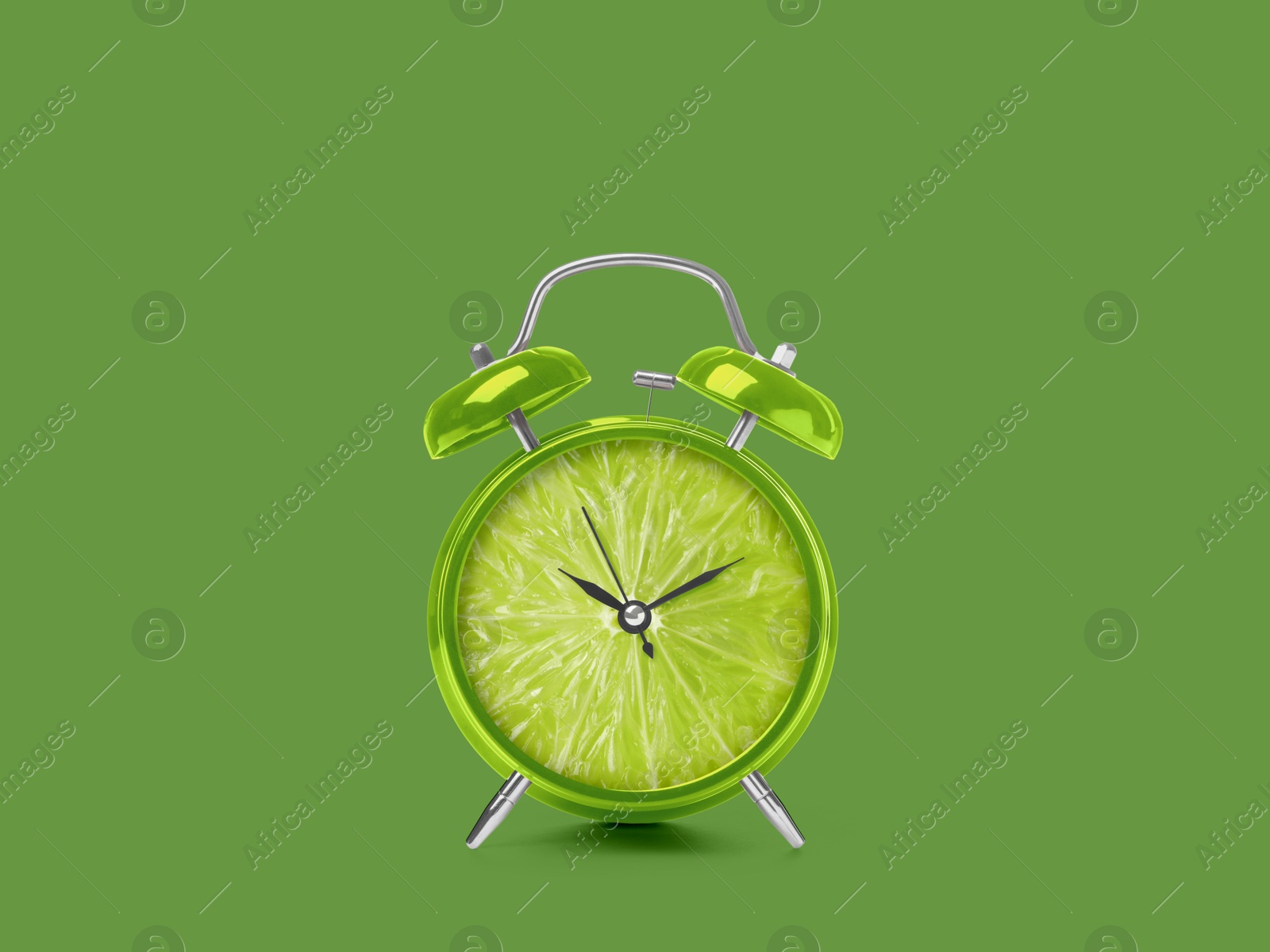 Image of Juicy lime on alarm clock dial against green background. Creative poster