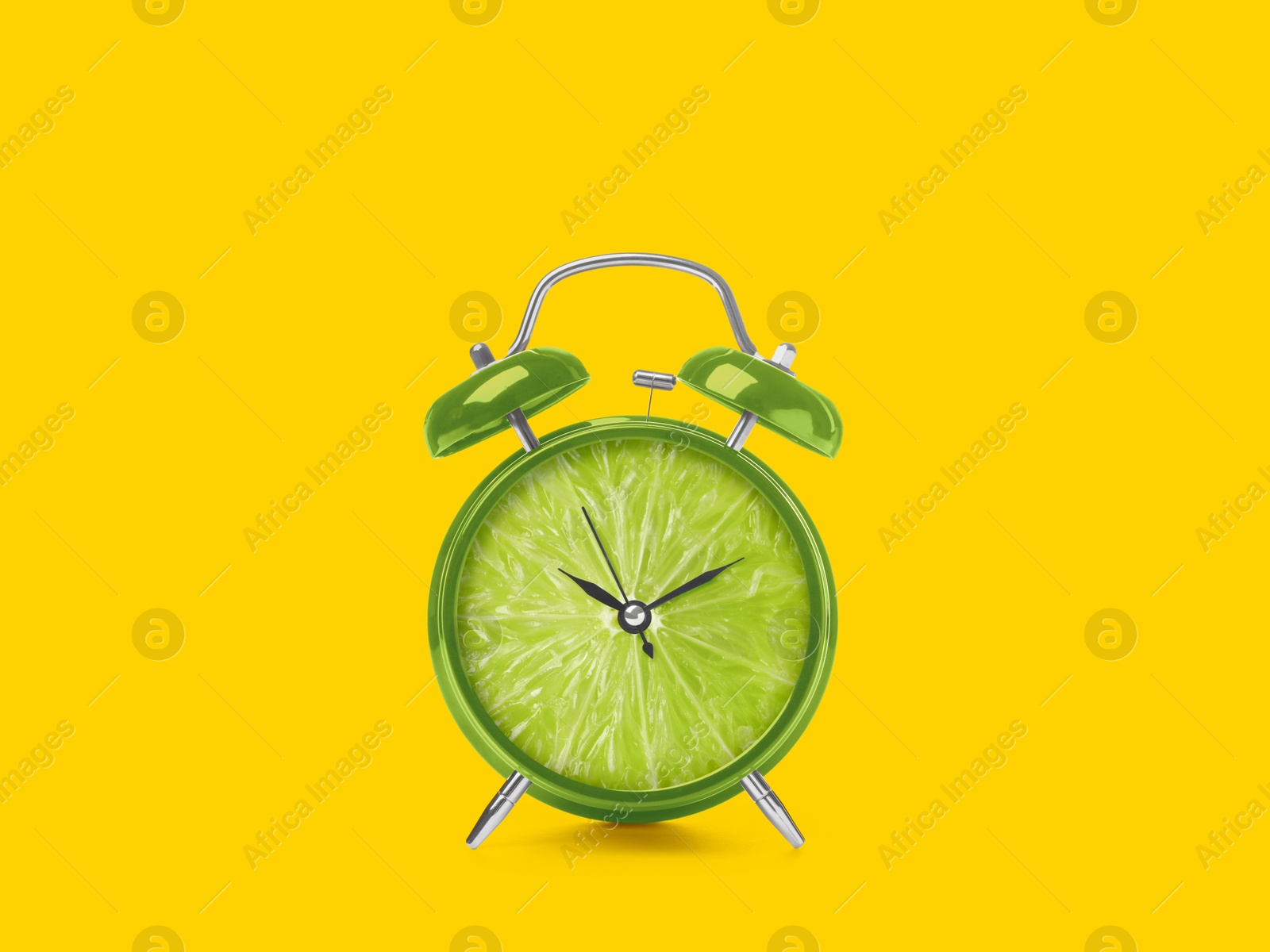 Image of Juicy lime on alarm clock dial against golden background. Creative poster