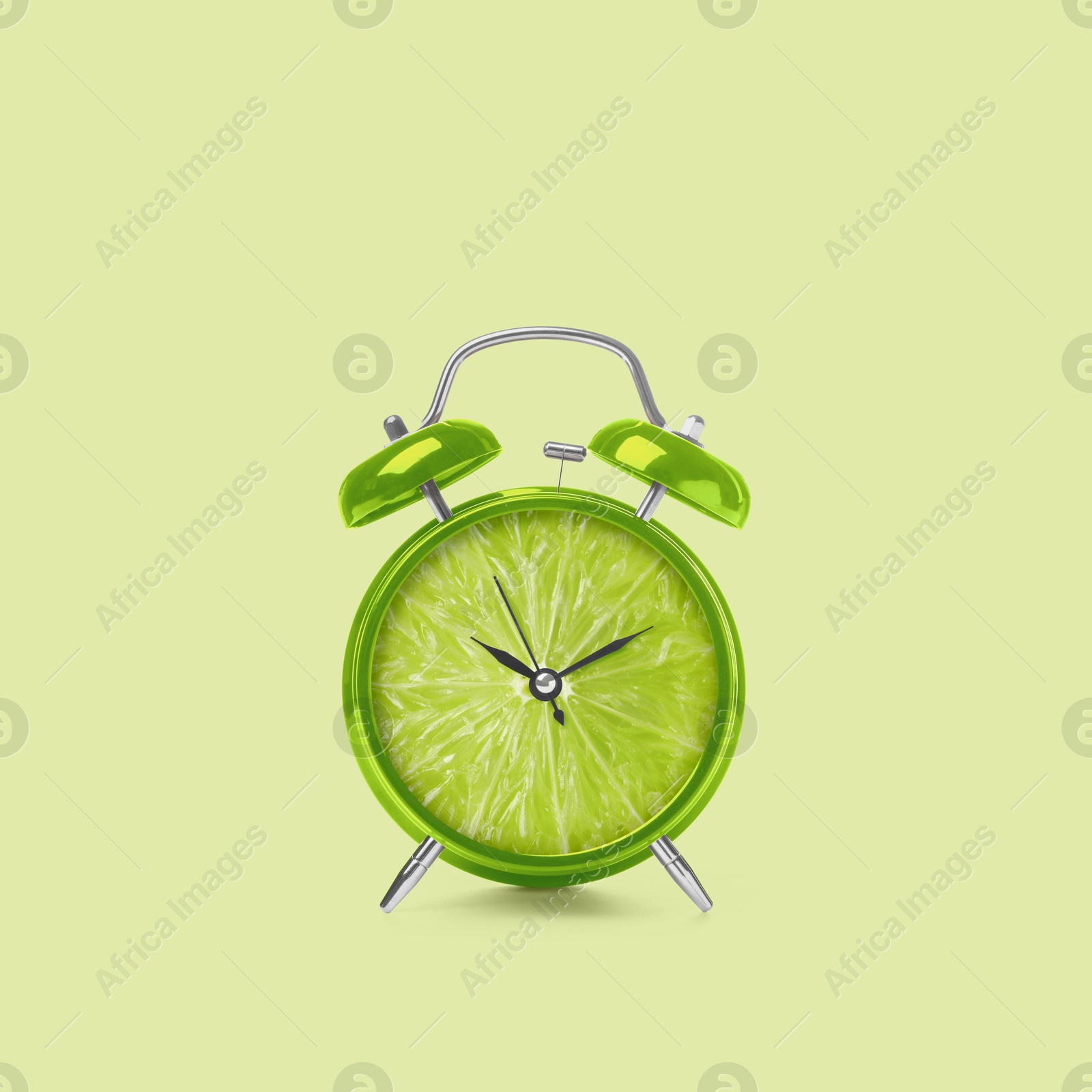 Image of Juicy lime on alarm clock dial against light green background. Creative poster